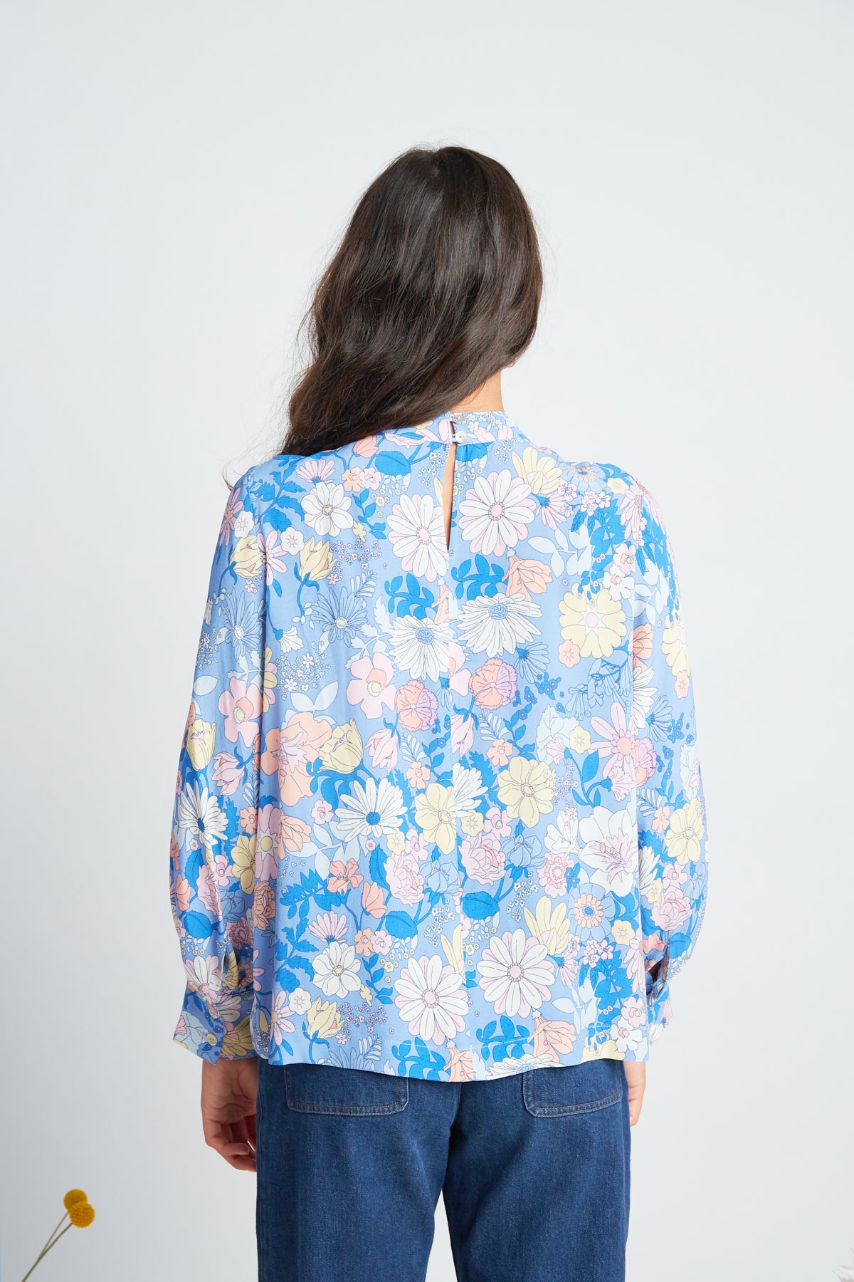 Manuela blouse by twenty-seven names. An elegant long-sleeved blouse with a high-neck panel, and gathers at the neck and cuff. Pictured in Periwinkle - multi colour pastel custom Botanical print on periwinkle blue base.