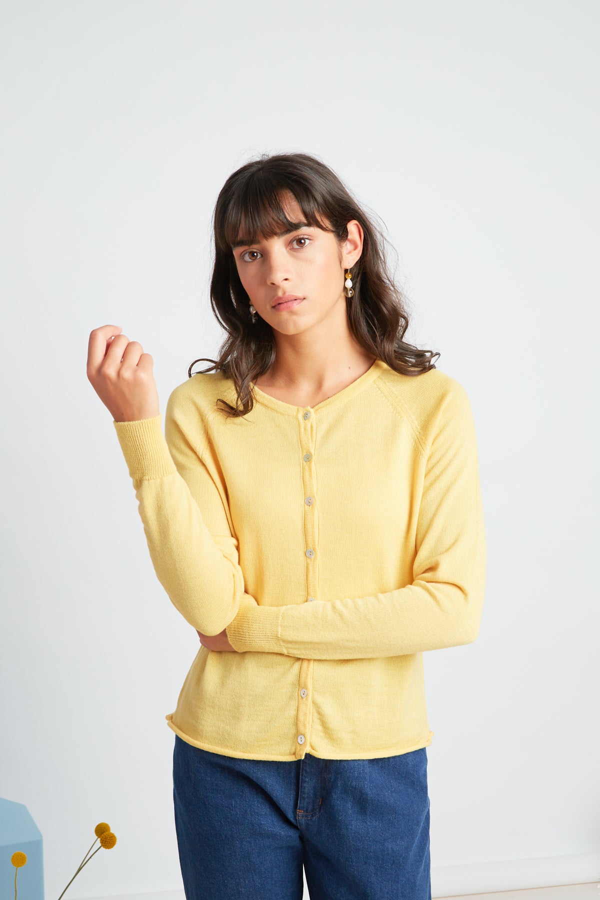 Daybreak cardigan by twenty-seven names. A chic little light-weight merino cardigan with raglan sleeves and shell buttons. Pictured in soft yellow.